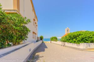 a sidewalk next to a building and the ocean at Zutenica Seaside Residence in Metajna