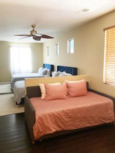 a bedroom with two beds and a couch at Tiki Boho Pool Spa Arcade Mini Golf BBQ in Indio
