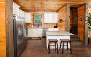 a kitchen with a stainless steel refrigerator and wooden walls at Beary Relaxed in Sevierville