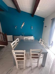 een tafel en stoelen in een kamer met een blauwe muur bij Maison 3chambres avec piscine in Istres