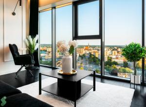 a living room with a table and large windows at HANZA Black & White 17th floor SPA & Pool Free Parking by Stayly in Szczecin