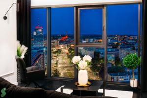 a living room with a view of a city at HANZA Black & White 17th floor SPA & Pool Free Parking by Stayly in Szczecin