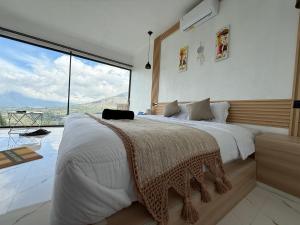 a bedroom with a large bed and a large window at Pinggan Plato in Baturaja