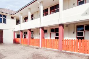an orange fence in front of a white building at Urbanview Hotel Falah Residence Syariah By RedDoorz in Padang