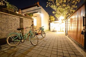 two bikes parked next to a brick wall at night at Villa Chintana Sanur - Tropical lush landscapes, and serene atmospheres in Sanur