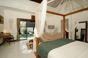 a bedroom with a canopy bed and a desk at Villa Chintana Sanur - Tropical lush landscapes, and serene atmospheres in Sanur +24 photos