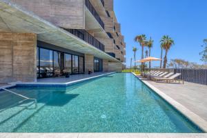 a swimming pool in front of a building at OR Cabo Boutique Residences by Lumina in Cabo San Lucas