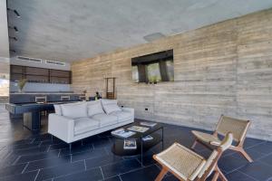a living room with a white couch and a piano at OR Cabo Boutique Residences by Lumina in Cabo San Lucas