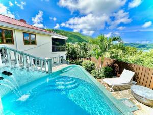 una piscina davanti a una casa di Waterfall Pool Villa with Private Mini Golf Course a Coral Bay