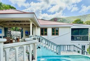 una casa con piscina e balcone di Waterfall Pool Villa with Private Mini Golf Course a Coral Bay