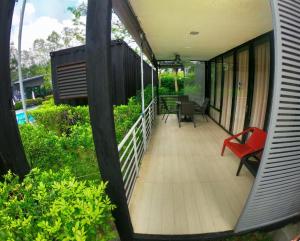 a balcony of a house with a red chair at The Kabin in Jeram