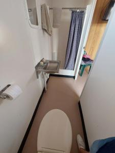 une petite salle de bain avec toilettes et lavabo dans l'établissement Birdsville Tourist Park, à Birdsville