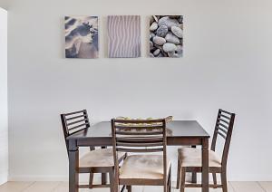 un tavolo da pranzo e sedie in camera di Panoramic Ocean View CBD Appartment a Yeppoon