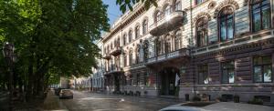 um edifício antigo numa rua com carros estacionados ao lado em Londonskaya SPA Hotel em Odessa