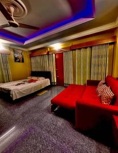een slaapkamer met een bed en een rode bank bij Dream Holiday Resort in Ināni