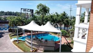 een uitzicht op een zwembad met een witte parasol bij Dream Holiday Resort in Ināni +57 foto's