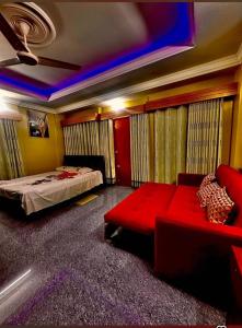 een slaapkamer met een bed en een rode bank bij Dream Holiday Resort in Ināni