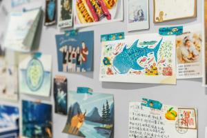 un muro con foto e calendari sopra di 琉意旅宿 a Xiaoliuqiu