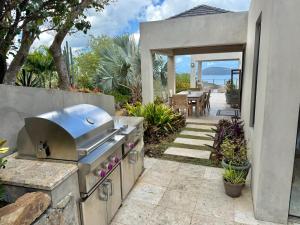 a outdoor kitchen with a grill and a patio at Window to the Sea - Phenomenal Pool and Hot Tub Villa in East End
