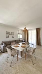 a living room with a couch and a table and chairs at Коттедж на берегу Иссык-Куля in Cholpon-Ata