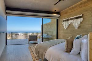 a bedroom with a large bed with a view of the ocean at OR Cabo Boutique Residences by Lumina in Cabo San Lucas