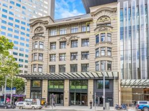 a large building with cars parked in front of it at The Clocktower Light and Airy Studio on Bourke St in Melbourne