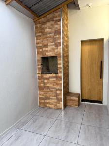 uma lareira de tijolos em uma sala com uma porta de madeira em Casa com garagem privativa, Perto do Centro em Joinville