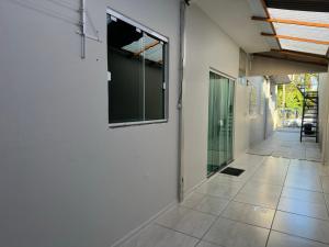 um corredor com paredes brancas e pisos em azulejo em Casa com garagem privativa, Perto do Centro em Joinville