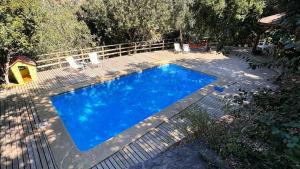 a blue swimming pool with a fence around it at Oceana Suites Laguna de Aculeo in Paine