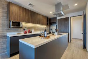 a kitchen with a counter with a bottle of wine at OR Cabo Boutique Residences by Lumina in Cabo San Lucas