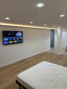 een kamer met een bed en een tv aan de muur bij Villa Clara chambre double in La Ciotat