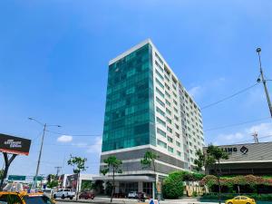 a tall glass building on a city street at Suite de lujo cerca al aeropuerto, terminal, mall sol in Guayaquil