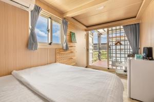 una camera da letto con un letto e una finestra di 琉意旅宿 a Xiaoliuqiu