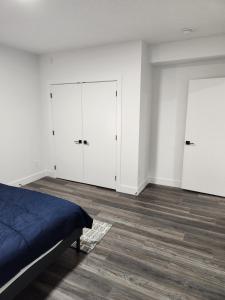 een slaapkamer met witte muren en een bed en 2 kasten bij Home Away from Home 2 bedrooms in Edmonton +2 foto's