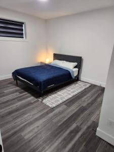 een slaapkamer met een bed en een houten vloer bij Home Away from Home 2 bedrooms in Edmonton