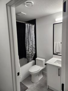 een witte badkamer met een toilet en een wastafel bij Home Away from Home 2 bedrooms in Edmonton
