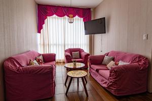 a living room with two red chairs and a table at Top Rated Apartment with Parking and Full Comfort in Tarapoto