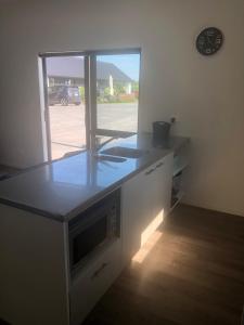 a kitchen with a counter top and a window at Night Winds Homestay in Ohaupo
