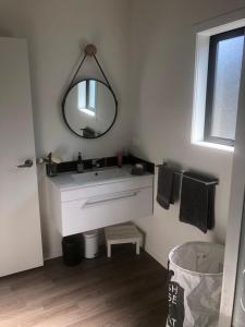 a bathroom with a white sink and a mirror at Night Winds Homestay in Ohaupo