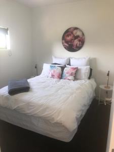 a bed with white sheets and pillows in a bedroom at Night Winds Homestay in Ohaupo