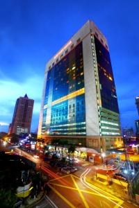 un edificio alto con luces encendidas en una ciudad en New York Hotel en Johor Bahru