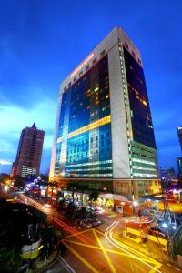 a tall building with lights on in a city at New York Hotel in Johor Bahru