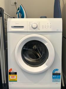 a white washing machine sitting in a room at Supernova B -2 Bedrooms in Lake Tekapo +3 photos
