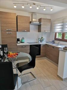 a kitchen with a table with a bowl of fruit on it at Garten House in Kornić