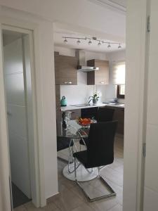 a kitchen with a table and a black chair at Garten House in Kornić