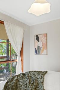 una camera da letto bianca con un letto e una finestra di Tranquil Cul de Sac Family Retreat in Lilydale a Lilydale
