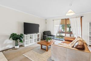 un soggiorno con un divano e una TV di Tranquil Cul de Sac Family Retreat in Lilydale a Lilydale