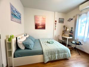 a bedroom with a bed and a desk in it at LovelyPhimHousE in Ban Nong Khwang Tawan