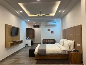 兰斯顿The Shalam Resort श्रीकृष्ण शरणं मम的一间带床和平板电视的卧室