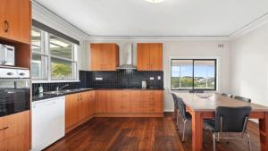 eine Küche mit Holzschränken und einem Holztisch in der Unterkunft Ashcroft Cottage in Nambucca Heads